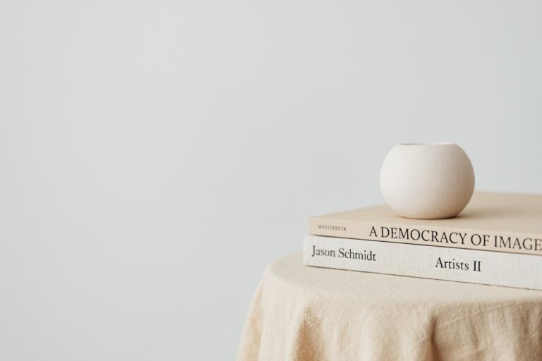 Simple and elegant composition of a small vase placed on books atop a table, perfect for minimalist design themes.