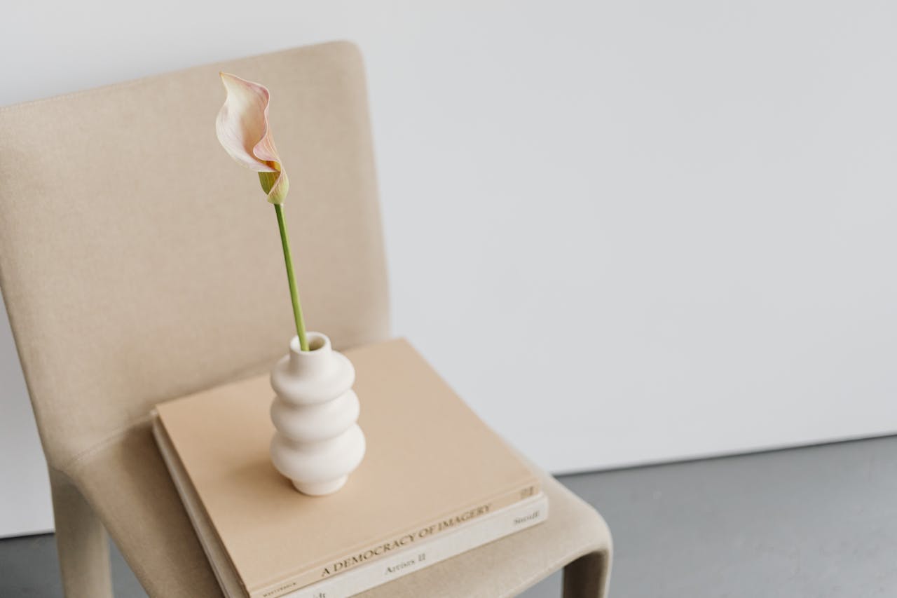 Elegant calla lily in a vase on a chair, showcasing minimalist design.