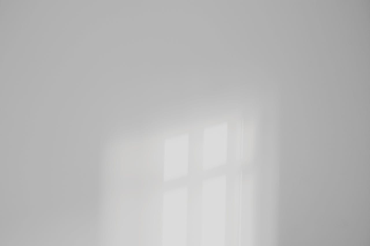 Soft light reflection on a plain white wall creating a minimalist aesthetic.